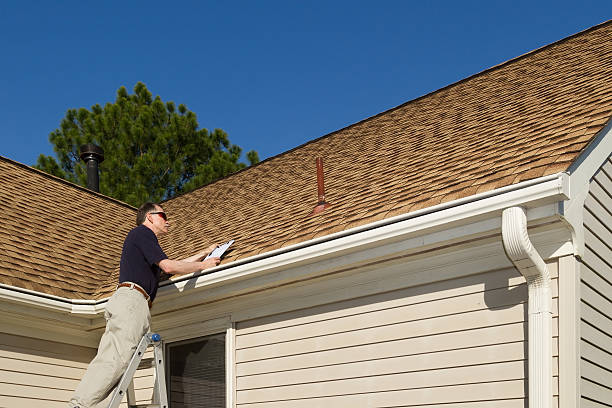 Home inspector examines a residential roof by Peak to Peak Roofing